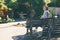 Pensive middle aged woman is sitting alone outdoors on bench. Senior lady relaxing in a deserted place. Retired woman in