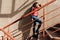 Pensive mulatto girl standing near wall on stairs