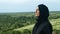 Pensive Muslim woman in black headscarf admiring nature landscape breathing freedom closeup slowmo