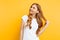 Pensive positive girl with a smile looks to the side, on a yellow background