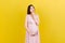 Pensive pregnant woman choosing name for baby on colored background. Dream and Happy Pregnant Woman Thinking Imagining Motherhood