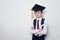 Pensive schoolboy wearing students hat and crossed his arms. Children education concept. White background, copy space