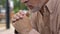 Pensive senior grandfather sitting in garden, nursing home, old age loneliness