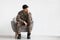 Pensive soldier sitting at armchair over white background