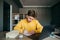 Pensive student sitting at home at a desk with a laptop and books and writing with a pen in a notebook homework. Guy is studying