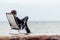 Pensive Teen on his Chair Facing at the Ocean