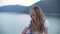 Pensive teenage girl sitting and looking down on sea coast