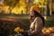 Pensive trendy woman in beige coat and hat sitting