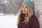 Pensive woman leaning against tree in winter