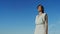 Pensive woman looking forward isolated blue sky