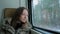 Pensive woman relaxing and looking out of a train window