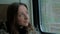 Pensive woman relaxing and looking out of a train window