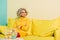 pensive woman in retro clothing with golden fish in aquarium on table at colorful apartment, doll