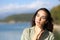 Pensive woman thinking looking at side in a lake