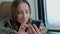 Pensive woman traveling on a train and using a smartphone