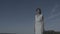 Pensive woman walking isolated blue sky ungraded