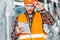 pensive worker in safety vest looking on notepad