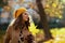 Pensive young 40 years old woman in brown coat and yellow hat