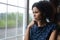 Pensive young african ethnicity woman looking out of window.