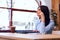 Pensive young beautiful businesswoman at office, looking at wind