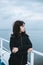 Pensive young girl looking to the sea from boat. Teenager girl at ferryboat. Cold grey sea