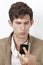 Pensive young man reading text message against white background