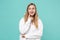 Pensive young woman girl in casual white hoodie posing isolated on blue turquoise background studio portrait. People