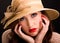 Pensive young woman wearing a very large straw hat for summer.