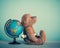 Pensivemature teddy bear sitting near globe and dreaming about new adventure, vintage style. Travel concept