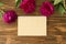 Peonies, empty notepad craft paper sheet on wooden background