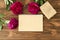 Peonies, empty notepad craft paper sheet on wooden background