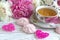 Peonies flowers pink cup of tea rattan hearts marshmallow on a white wooden background - stock image.