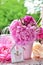 Peony bunch in vase on the table in the garden