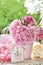 Peony bunch in vase on the table in the garden with color effect