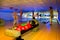 People active bowling in dark bowling hall
