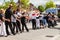 People of all ages line dancing in the street.