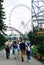 People in an amusement Park on the background of carousels, slides, Ferris wheels