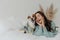 People and animals concept. Joyful pretty young woman express love to dog, spends leisure time with pet, lie together on bed,