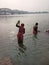 People bathing and women turning money from the river