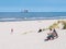 People on beach and North Sea with offshore platform, West Frisian island Ameland, Friesland, Netherlands