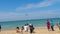 People on the beach, plane landing