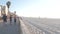 People on beachfront way running, sport recreation on beach in California, USA.