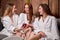 people, beauty, lifestyle, technology and relaxation concept - caucasian women with smartphone social networking at spa