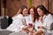 people, beauty, lifestyle, technology and relaxation concept - caucasian women with smartphone social networking at spa