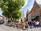People, bicycles and restaurants on Walplein square in Bruges, Belgium