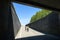 People biking downwards into tunnel under highway