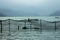 A people in a boat on the lake against the evening silhouettes of mountains. fishing net on the water