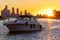 People on a boat sailing in front of Humber Bay and Ontario Place as the sun sets in the background