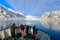 People on the boat. Winter mountain with snow, blue glacier ice with sea in the foreground. Blue sky with white clouds. Snowy hill