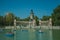 People with boats on pool in front of monument in a park of Madrid